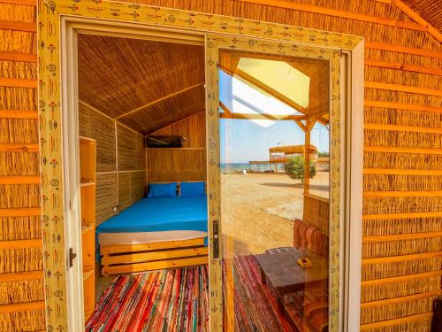 1 dormitorio con 1 cama dentro de una casa de madera en Baraka Camp en Taba