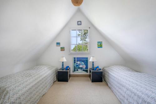 - une chambre mansardée avec 2 lits et une fenêtre dans l'établissement Séjour en famille à Sarzeau - 270m de la plage, à Sarzeau