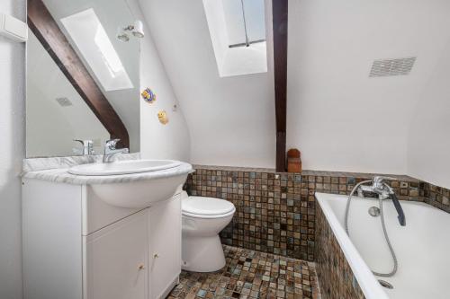 La salle de bains est pourvue d'un lavabo, de toilettes et d'une baignoire. dans l'établissement Douce parenthese en famille a Sarzeau, à Sarzeau