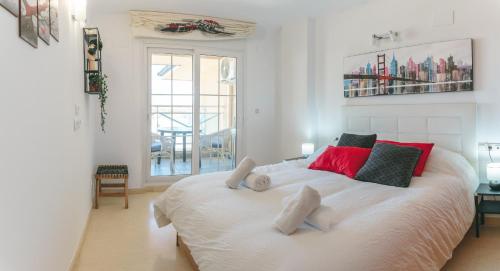 a bedroom with a large white bed with red pillows at Abity Beach Varadero 3B in La Manga del Mar Menor