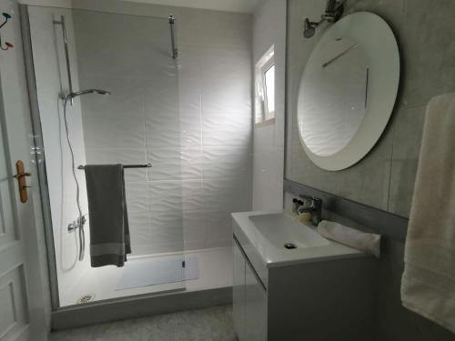 a bathroom with a sink and a mirror and a shower at Sao Rafael Beach Flat in Albufeira