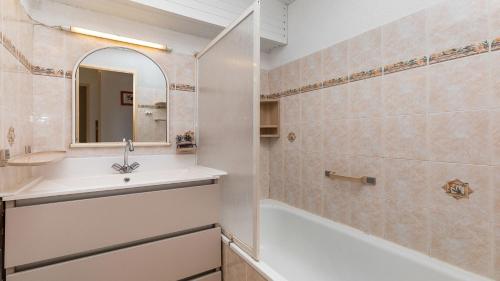 une salle de bain avec un lavabo, une baignoire et un miroir dans l'établissement Port Lano 112 - Appt cosy - 7 Personnes, au Cap d'Agde