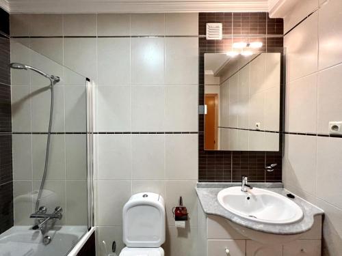 uma casa de banho com um lavatório, um WC e um espelho. em Pêra Brightness Villa by Homing em Pêra