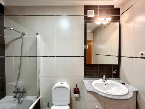a bathroom with a sink and a toilet and a mirror at Pêra Brightness Villa by Homing in Pêra