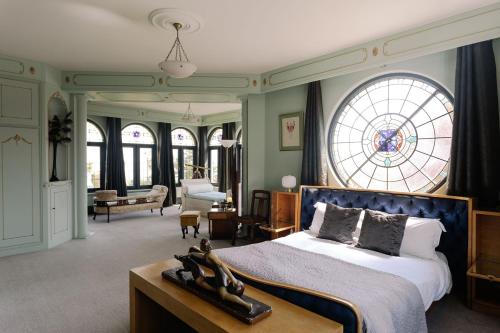 a bedroom with a bed and a large window at Christie Mansion - Luxury Cottages in Shanklin