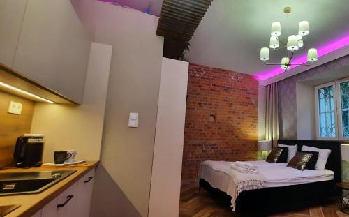 a room with a bed and a brick wall at Apartament Tango in Krakow
