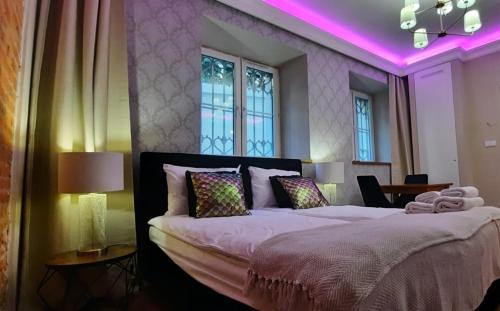 a bedroom with a large bed with purple lighting at Apartament Tango in Krakow