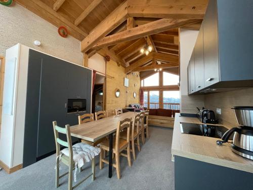 une cuisine et une salle à manger avec une table et des chaises en bois dans l'établissement Shatzy, à La Rosière