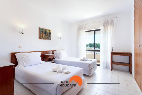 a hotel room with two beds and a window at #132 Velamar 414 by Home Holidays in Caliços