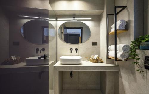 a bathroom with a sink and two mirrors at Alea Suites -Adults Only and Kids 14 Plus in Asprovalta