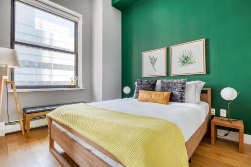 Dormitorio verde con cama y ventana en Tribeca 1BR w Gym Doorman Roof deck NYC-54 en Nueva York