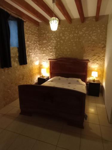 a bedroom with a bed and two lamps on two tables at La Sérénité in Auriac-de-Bourzac