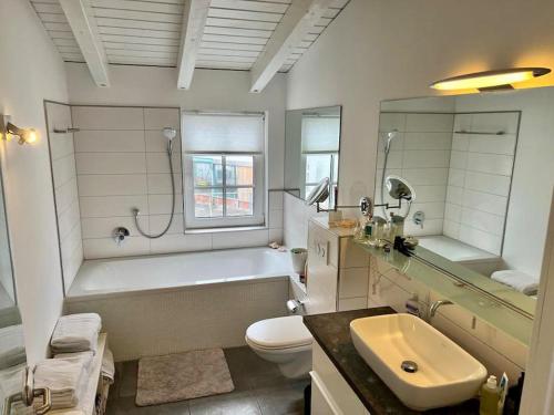 ein Badezimmer mit einer Badewanne, einem WC und einem Waschbecken in der Unterkunft Wunderschöne Stadtwohnung in Würzburg