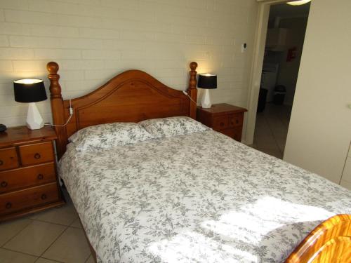 a bedroom with a bed and two lamps on dressers at Clan Ranald Holiday Unit 1 in Edithburgh
