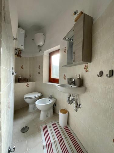 a bathroom with a toilet and a sink at AngeLina al borgo in Aieta