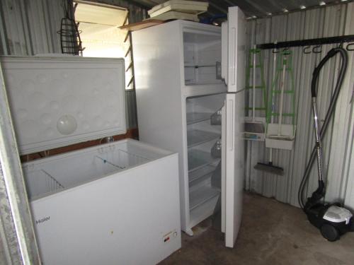 a kitchen with an empty refrigerator in a garage at Clan Ranald Holiday Unit 1 in Edithburgh