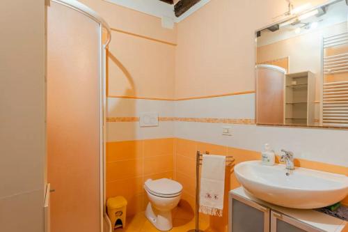 Un baño con lavabo, inodoro y espejo. en Casa Di Laino, en Lucca