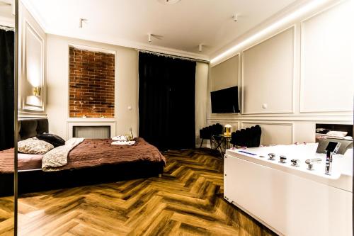 a bedroom with a bed and a tub in it at Luxury Jacuzzi Apartment in Kraków
