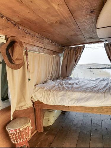 Gipsy Van Fuerteventura في بويرتو ديل روزاريو: سرير في الجزء الخلفي من الغرفة مع طاولة