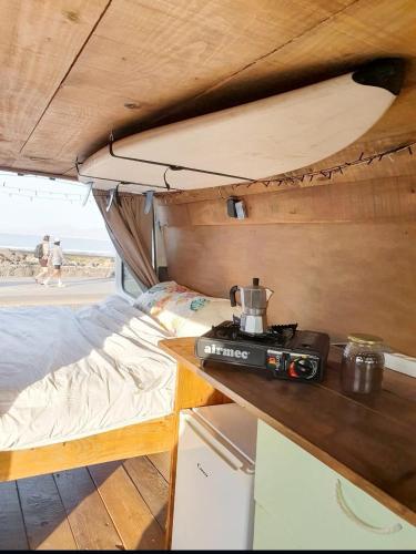 um quarto com uma cama e uma câmara sobre uma mesa em Gipsy Van Fuerteventura em Puerto del Rosario