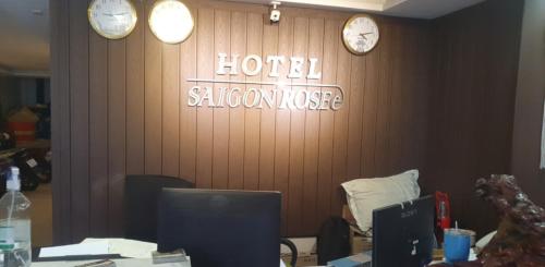 un bureau avec des horloges sur le mur et un bureau dans l'établissement SaiGon Rose Hotel, à Hô-Chi-Minh-Ville