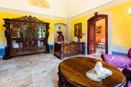 a living room with a wooden cabinet and a table at Hotel Vécsecity in Hernádvécse