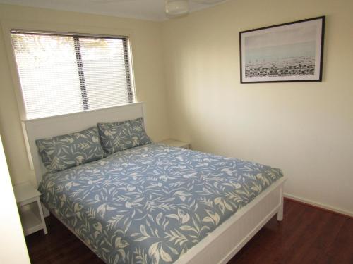 a small bedroom with a bed and a window at Lady Doris in Port Vincent
