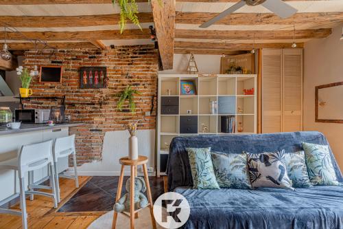 un salon avec un canapé bleu et une cuisine dans l'établissement R'Apparts T2 The Cool Place, à Grenoble