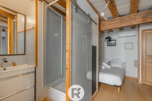Cette chambre comprend un lit et une salle de bains pourvue d'une douche. dans l'établissement R'Apparts T2 The Cool Place, à Grenoble