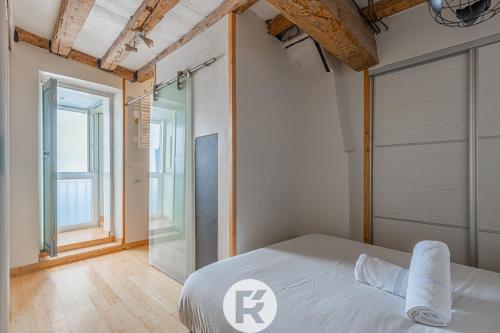 - une chambre avec un lit blanc et une porte en verre dans l'établissement R'Apparts T2 The Cool Place, à Grenoble