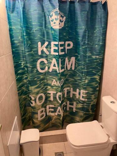 a shower curtain that says keep calm and go to the beach at Aggeliki Homes paradosiako nisiotiko in Poros