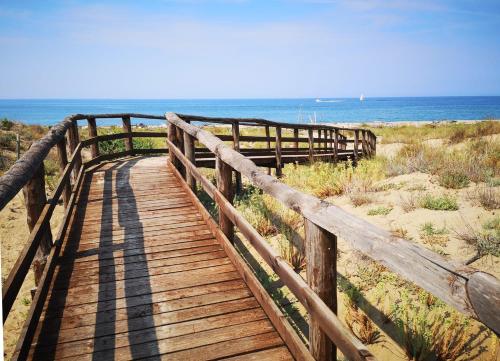 a wooden boardwalk to the beach with the ocean in the background at I Levrieri in Torre del Lago Puccini