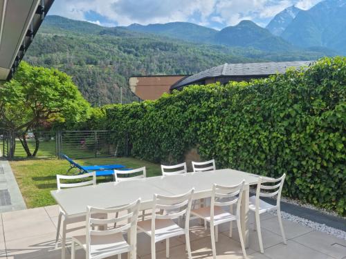 a white table and chairs on a patio with mountains at Suite vacanze Chabloz nel cuore della Valle d'Aosta in Nus