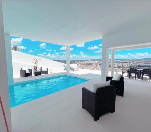 un soggiorno con piscina in una casa di Vila Pombal Tomar - Luxury Apartment with private pool and Castle View a Tomar