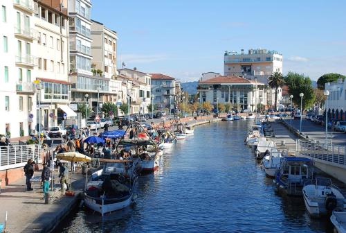 a group of boats docked in a canal with buildings at I Levrieri in Torre del Lago Puccini