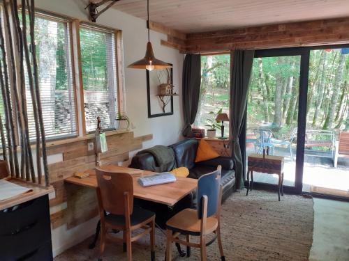 un salon avec une table et un canapé dans l'établissement Le gîte de la cabane de l'oiseau, à Couze-et-Saint-Front
