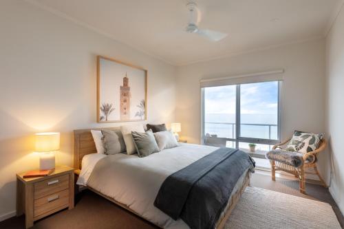 a bedroom with a large bed and a large window at Sol Living Beach House in Brentwood