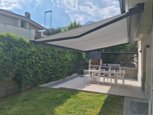 a patio with a table and chairs under awning at Suite vacanze Chabloz nel cuore della Valle d'Aosta in Nus
