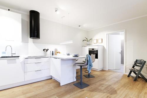 a white kitchen with a desk and a chair at Op’n Diek in Fehmarn