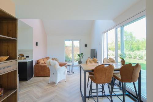 a living room with a dining room table and chairs at Erve Mulder vakantiehuis met eigen jacuzzi en eigen sauna in Weerselo