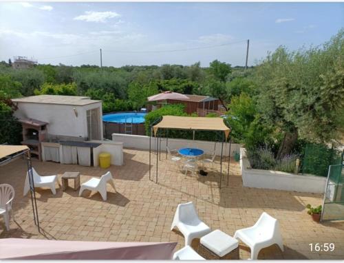 un patio con tavolo, sedie e piscina di Casa Dolce Puglia Casa Vacanza a Castellana Grotte