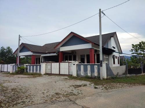 a house with a white fence in front of it at NikNa Homestay Batu Rakit - WIFI in Kampong Ru Tujoh