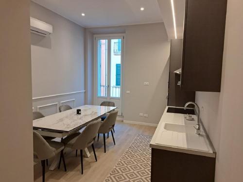 Una cocina y un comedor con mesa y sillas. en Eleganti Dimore, en Brescia