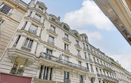 un grand bâtiment blanc avec un balcon dans l'établissement Amsterdam 11 - Saint-Lazare - Studio, à Paris