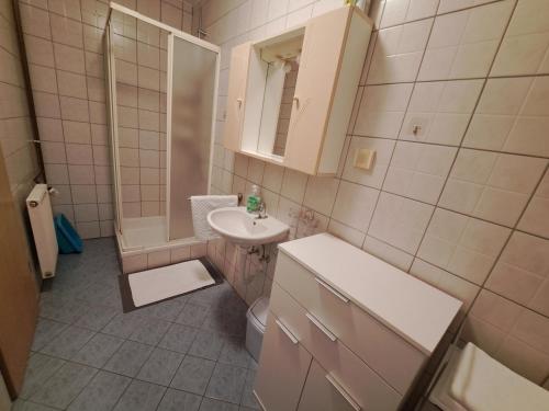 a bathroom with a sink and a toilet and a mirror at Apartment Leo in Baška