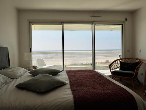 1 dormitorio con 1 cama y vistas al océano en Appart T4 lumineux avec terrasse vue mer, en Le Touquet-Paris-Plage
