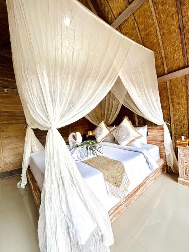 a bedroom with a bed with mosquito netting at Batur cottage in Kubupenlokan
