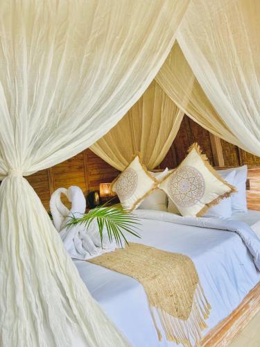 a bedroom with a white bed with a canopy at Batur cottage in Kubupenlokan