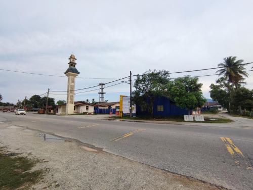 an empty street with a clock tower in the distance at NikNa Homestay Batu Rakit - WIFI in Kampong Ru Tujoh