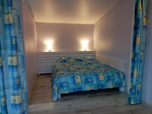 1 dormitorio con 1 cama y 2 luces en la pared en У моря.Крыжановка. en Kryzhanivka